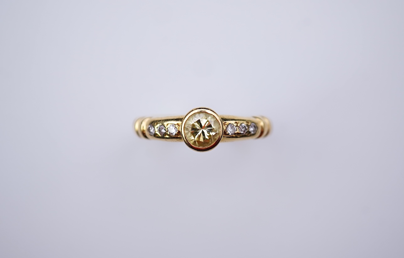 A yellow diamond and diamond ring